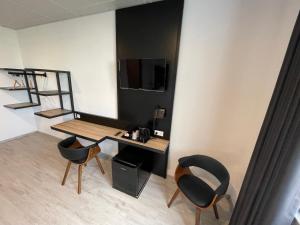 a room with a desk and two chairs and a television at Yebs Hotel in Günzburg +18 photos