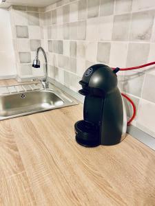 a tea kettle sitting on a kitchen counter next to a sink at Conest Studio in Iaşi