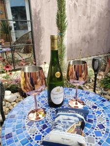 una botella de vino y dos copas de vino en una mesa en The Courtyard - Cosy, secluded with luxury suite en Walmer