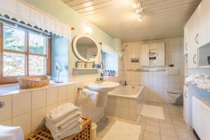uma casa de banho com um lavatório, um WC e um espelho. em Uriges Landhäuschen em Siegsdorf