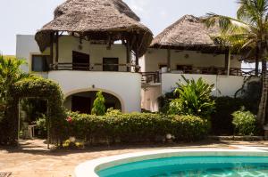a resort with a swimming pool and a building at Rischland Villas in Watamu