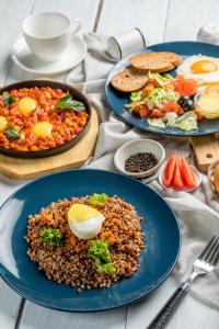 una mesa cubierta con platos de comida, huevos y judías en VolnaCity Hotel en Ufá