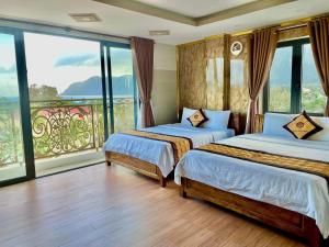 a bedroom with two beds and a large window at Hotel Minh Thắng 2 in Con Dao