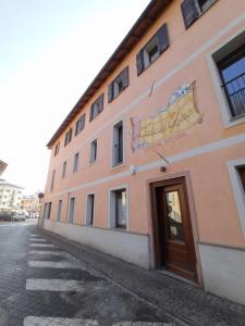 un bâtiment rose avec un panneau sur son côté dans l'établissement La Tana del Ghiro Locazione Turistica, à Sedico
