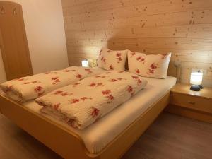 uma cama com duas almofadas em cima em Haus Mangard em Sankt Gallenkirch
