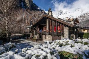 domek z bali w śniegu z górą w obiekcie Spacious chalet low-cost for a group holiday w mieście Courmayeur
