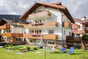 a large house with a yard with chairs at Villa Costa in Ortisei