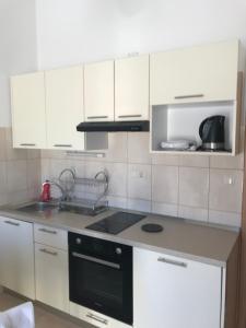 a kitchen with white cabinets and a black stove top oven at JELSA center-Sea view apartment near the beach - B2 in Jelsa
