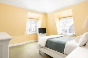 een slaapkamer met een bed en 2 ramen bij Pelham Court Hotel in Newport