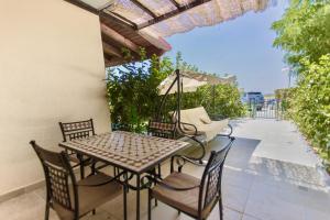 une terrasse avec une table, des chaises et un parasol dans l'établissement Deliziosa Villetta Mare Indipendente, à Marina di Pisticci