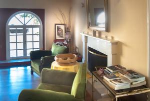 a living room with two chairs and a fireplace at Hotel Methanion in Methana