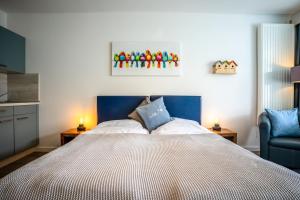 a bedroom with a large bed with a blue headboard at Studio 42 "Vogelfrei" in Grömitz