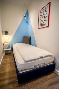 Ce lit se trouve dans un dortoir doté d'un mur bleu. dans l'établissement Studio 42 "Vogelfrei", à Grömitz