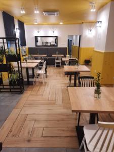 ein Restaurant mit Holztischen und -stühlen und einer Cafeteria in der Unterkunft Tom&Tom in Białogard