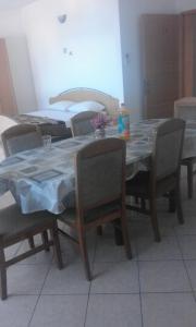 a dining room table with chairs and a table with a blue table cloth at Apartments IVAN in Duce (900) in Duće