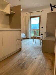 Zimmer mit einer Küche mit einem Tisch und einem Fenster in der Unterkunft Maso Fiorini in Rovereto