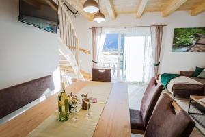 soggiorno con tavolo in legno e bicchieri da vino di Meine Auszeit – das ferienhaus a Sankt Georgen am Reith