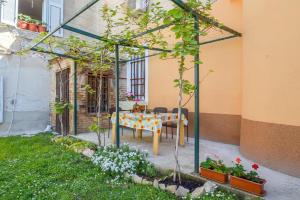 a patio with a table and some plants in a yard at Apartman Ivano in Pula