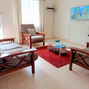 a living room with two chairs and a table at Twende Nanyuki Homes in Nanyuki