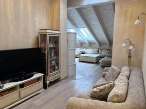 een woonkamer met een bank en een flatscreen-tv bij Garmisch Lux Apartment mit Sauna in Garmisch-Partenkirchen