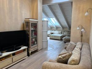 a living room with a couch and a flat screen tv at Garmisch Lux Apartment mit Sauna in Garmisch-Partenkirchen