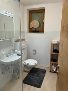 a bathroom with a toilet and a sink at Haus Colorado am Gaisberg in Scheffau am Wilden Kaiser +35 photos