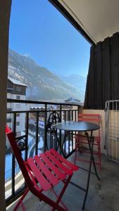 d'une table et de chaises sur un balcon avec vue. dans l'établissement Chamois de Chamonix, Confortable 2 pièces, balcon, parking gratuit, à Chamonix-Mont-Blanc