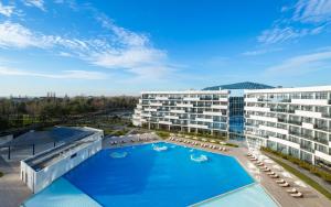 an image of a hotel with a swimming pool at Movenpick Resort & SPA Anapa Miracleon in Anapa