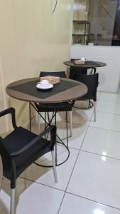 2 tables et chaises assises dans une pièce dans l'établissement BeB Hotel, à Macapá