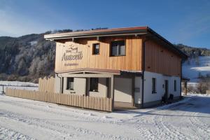 un edificio con un cartel en la nieve en Meine Auszeit – das ferienhaus en Sankt Georgen am Reith