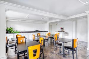a dining room with black tables and yellow chairs at OYO Hotel Baton Rouge East I-12 Louisiana in Baton Rouge
