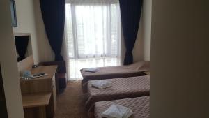 a hotel room with two beds and a window at Hotel Liani in Lovech