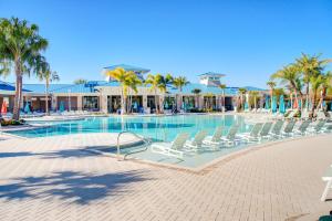 a swimming pool with lounge chairs and palm trees at Windsor Island Resort 237 in Davenport