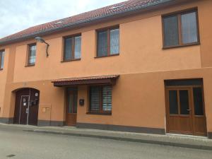 een oranje gebouw met twee deuren en ramen bij Cyklo-Moto apartmán in Lomnice nad Lužnicí