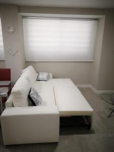 a white couch in a room with a large window at Loft Ciudad Jardín in Córdoba