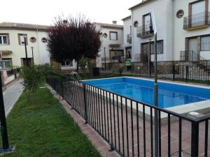 a swimming pool with a fence next to a building at Casa Mirian in Arroyo Frio