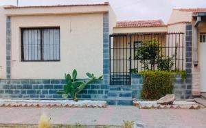 a house with a fence and a plant in front of it at Posada Mis Padres in Godoy Cruz