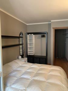 a bedroom with a white bed and a mirror at Casa Monique - Borgo Le Stalle Lunghe in Prato Nevoso