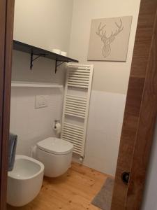 bagno con servizi igienici bianchi e lavandino di Casa Monique - Borgo Le Stalle Lunghe a Prato Nevoso