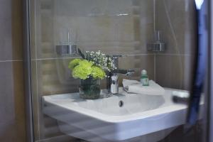 a bathroom sink with a vase of flowers on it at Haus am Hühnerdieb in Aachen