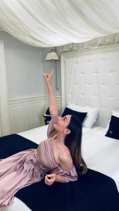 a woman laying on a bed with her arm in the air at Hotel Tito in Rome