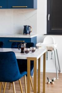 una cocina con armarios azules y una mesa con tazones. en Osada Mosorny Groń - Zawoja, en Zawoja