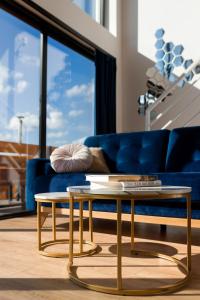 sala de estar con sofá azul y 2 mesas en Osada Mosorny Groń - Zawoja, en Zawoja
