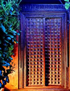 a wooden door with a pattern on it next to a plant at L'écrin de Rûmi in Vaires-sur-Marne