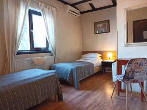 a hotel room with two beds and a window at Avalon Rooms in Oradea