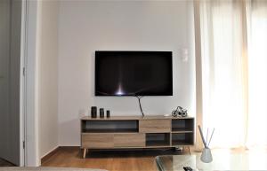 sala de estar con TV de pantalla plana en la pared en Khibra 1, en Volos