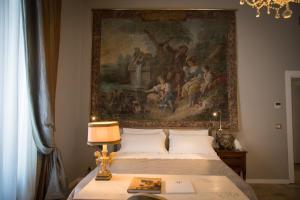 ein Schlafzimmer mit einem großen Gemälde über einem Bett in der Unterkunft Arnaboldi Palace in Pavia