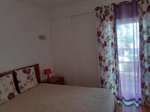 a bedroom with a bed and a window at Clube Meia Praia in Lagos