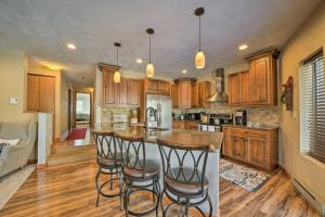 a kitchen with wooden cabinets and a island with bar stools at Idyllic Somerset Condo Ski, Hike and Relax! in Champion
