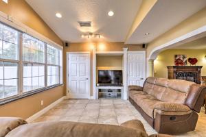 ein Wohnzimmer mit einem Sofa und einem TV in der Unterkunft Cozy Home in Heart of Tampa with Lanai and Pool! in Tampa